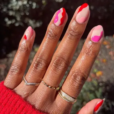 Wavy pastel pink, hot pink, and red nail design