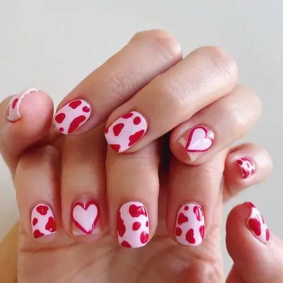 Pink and red nails with cow print and heart designs