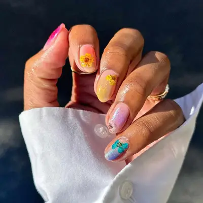 close up of nails with sheer shimmer in different colors matching a different dried flower on each nail