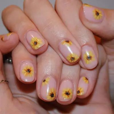close up of nails with bare base and handpainted yellow sunflowers on top