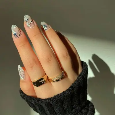 close up of nails with clear base and black and white hand painted flowers