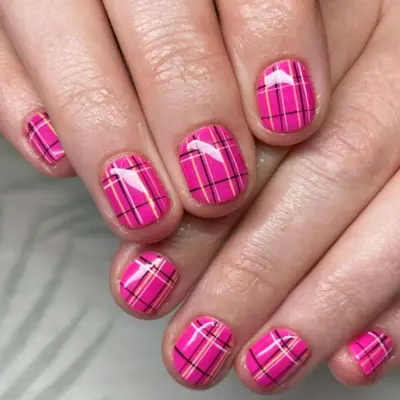 Short squoval nails with a pink plaid design.