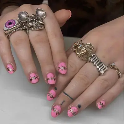 Pink short nails with gold barbed wire nail art