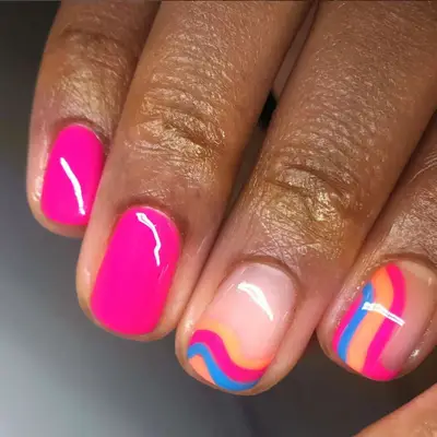 Short pink nails with two accent nails with bright colored waves.