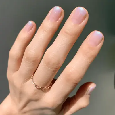 Light pink manicure on short squoval nails.