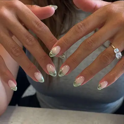 Person with milky white nails and blobby green chrome French tips