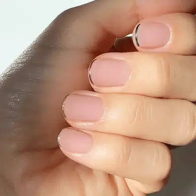 Person with short nails with multicolor chrome tips