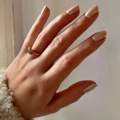 Person with short peach chrome nails