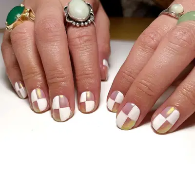 Person with short chrome checkerboard nails