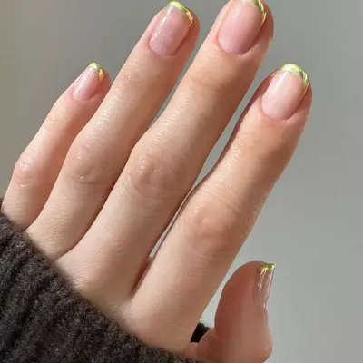 Person with gold chrome French tips