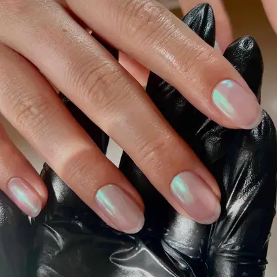 Person with iridescent glazed chrome nails