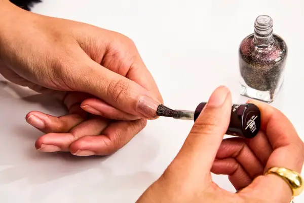 A person using Sally Hansen Miracle Gel Nail Polish on their thumb nail