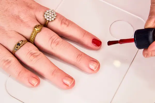 A person applying Dior Vernis Nail Polish to their pointer finger