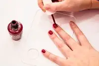 A person painting their nails red with OPI GelColor Polish