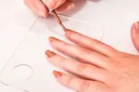 A close-up of a person painting their nail with the ORLY Gel FX Gel Nail Color