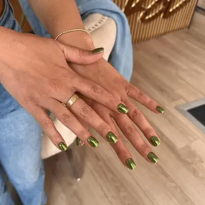 a short, mossy-green manicure topped with shiny chrome