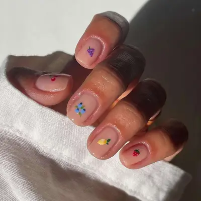 Manicure with neutral base and minimalist fruit designs