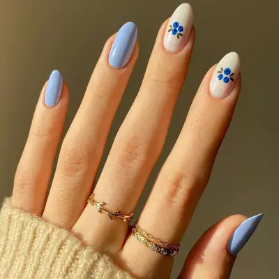 Manicure with light blue base and accent nails with white base and blueberry designs