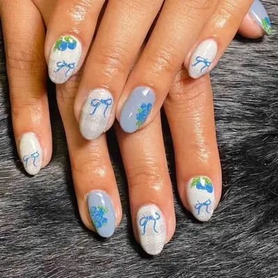 Blue and white manicure with ribbon, plaid, and blueberry designs
