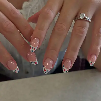 A french manicure with berries on the on tips