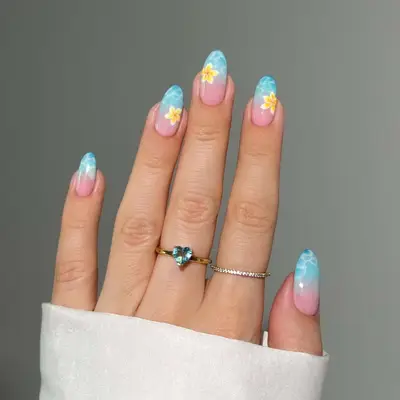 Hand with floral nail art design and rings on fingers