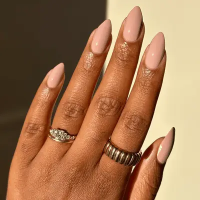 A close up of nails with pink cream polish.