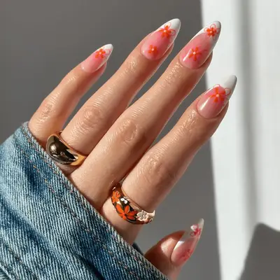 close up of long nails with white french tips and pink flowers.