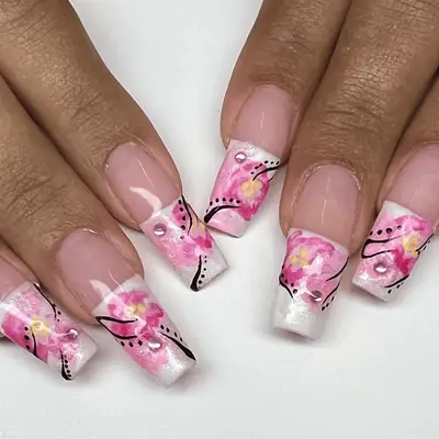 Square long nails with white French tips painted with classic cherry blossom florals.