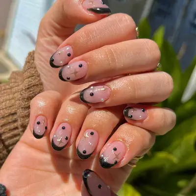 Black French manicure with black studs and gold star designs