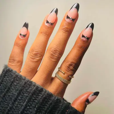 French manicure with black tips, accent design, and rhinestone studs near cuticle