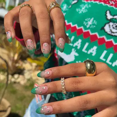 Studded French manicure with green glitter tips and clear rhinestone gems