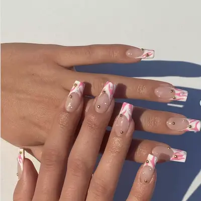 white french manicure with pink designs and gemstone accents