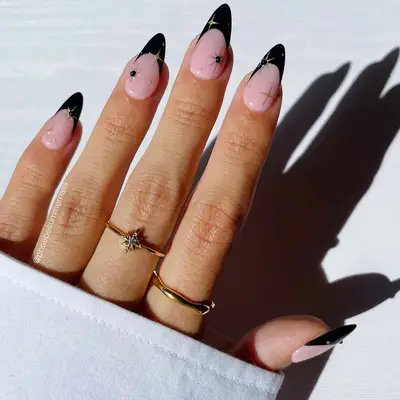 Black French manicure with gold star detailing