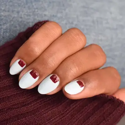 White manicure with rectangular accents in deep red/maroon.