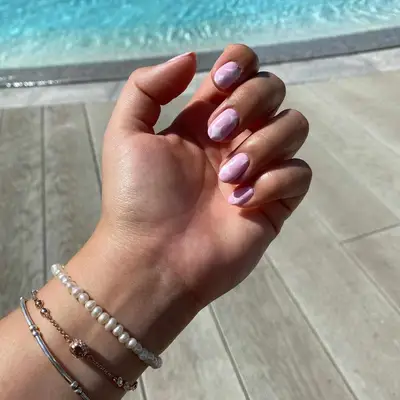 A baby pink manicure with white stars