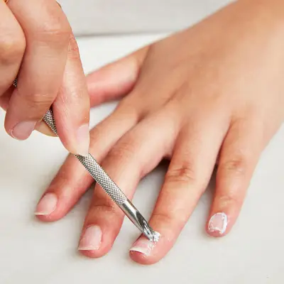 Woman chips away at remaining polish on her fingernail