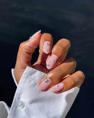 Close-up of silver chrome nails with extended square tips and bubble designs
