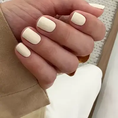 Short beige nails with a micro white French tip