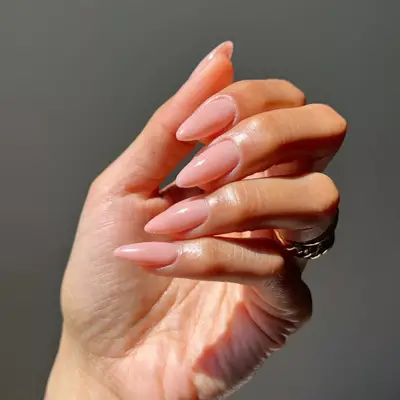 Long, almond-shaped sheer pink glossy nails