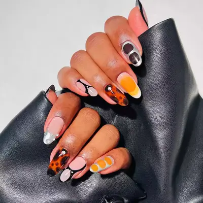 Orange futuristic nails with black and silver design