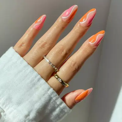 sherbert orange and pink nails with white swirly line 