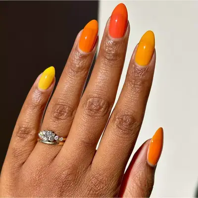 different tones of bright orange and yellow nails