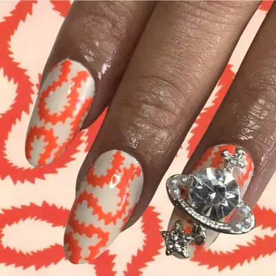 off white nails with orange wire design and Vivienne Westwood charm accent