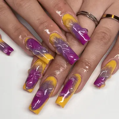 Close up of long square nails with purple and yellow abstract art.