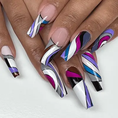 Close up of long geometric purple, blue and grey nails.