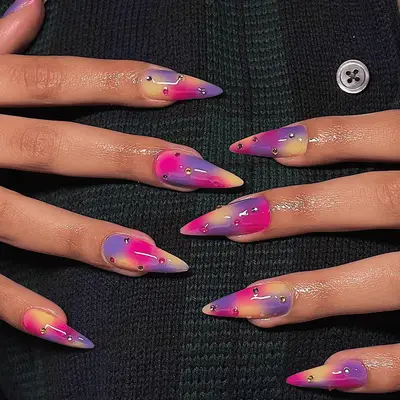 Close up of long nails with pink, purple, and orange airbrushing.