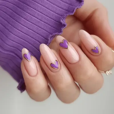 A milky manicure with purple hearts, outlined in gold