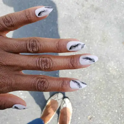 Matte white nails with black feather designs