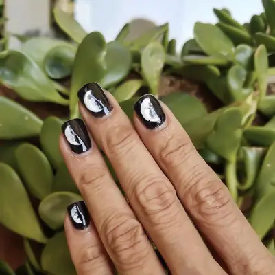 Short black nails with white moon phase designs