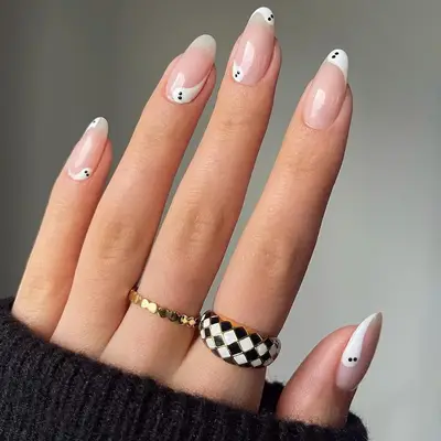Nude nails with black-and-white minimalist ghost designs at the tip and cuticle